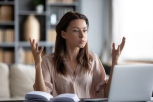 woman raises hands and considers finding ways for managing your anger