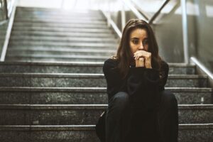woman sitting on steps considers if she's experiencing constant depression