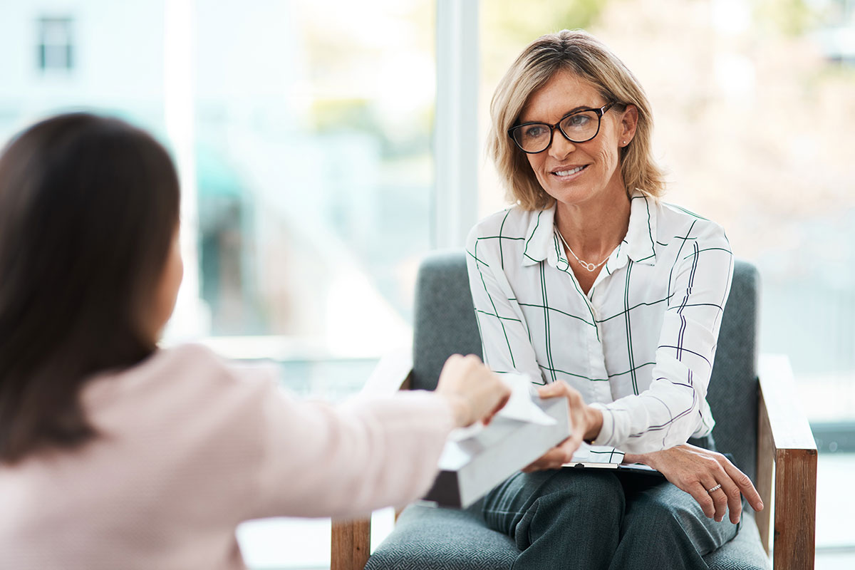 therapist offering upset women a tissue