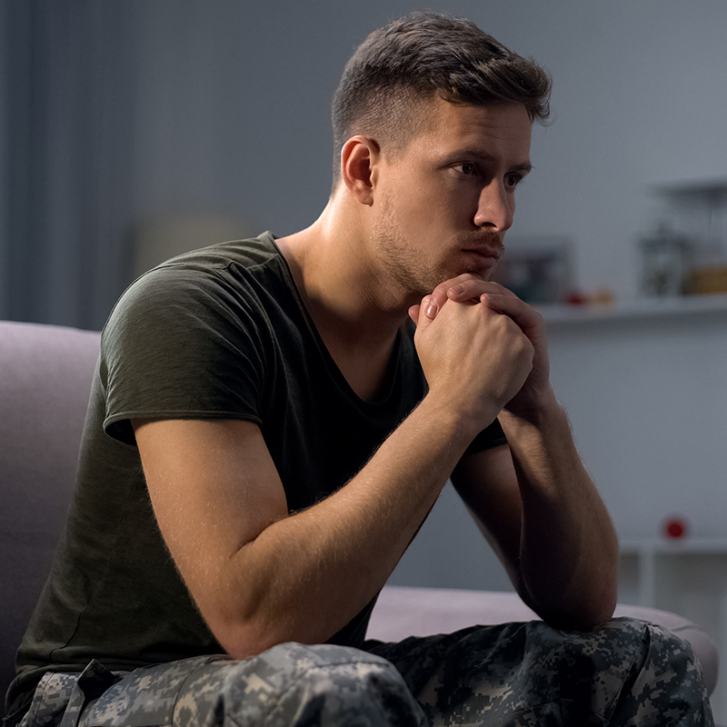 Upset soldier remembering terrifying war, suffering ptsd, psychological help