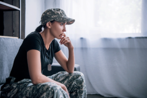 a woman in a military uniform sits and thinks about the link between trauma and depression