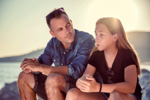 a father talks to his young daughter discussing the importance of family conflict resolution