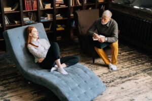 a woman sits on a chair talking to her therapist during her anxiety therapy in bloomfield