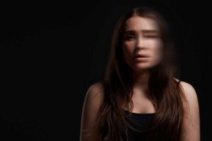 a blurry upset woman thinks about grounding techniques for dissociation