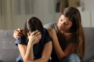 woman consoles another struggling woman and tells her about tms for depression